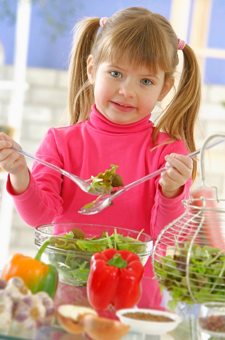 Young girl mixing the salad