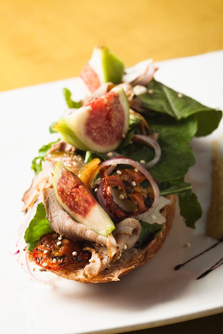 Röstbrot mit Putenbrustscheiben, Tomaten und Feigen belegt