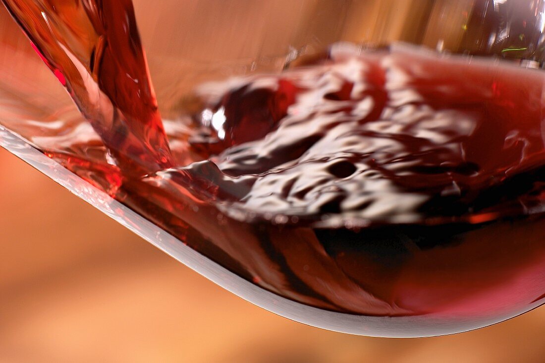 Rotwein in ein Glas schenken