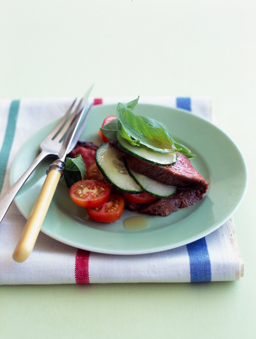 Cold roast beef with cucumber, tomato and basil salad