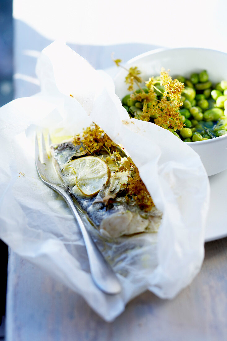 Fisch mit Kräutern und Limette, im Backpapier gegart, Saubohnen mit grünen Erbsen