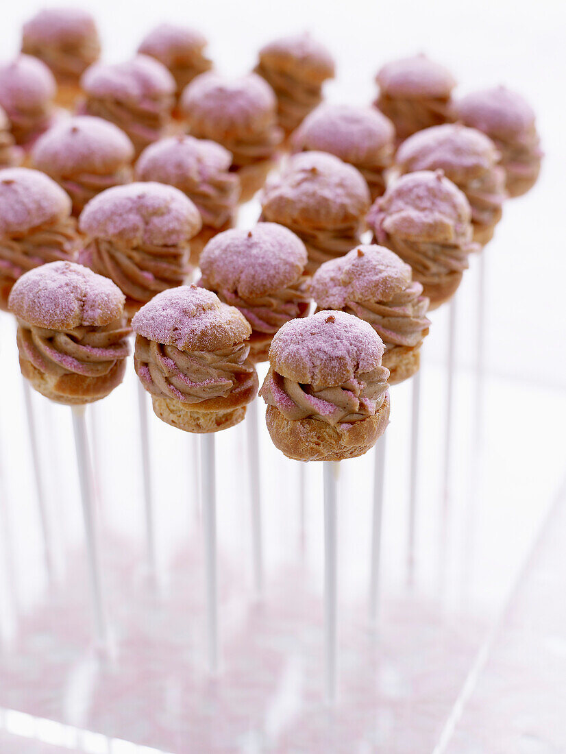 Mini hazelnut choux buns coated in pink icing sugar