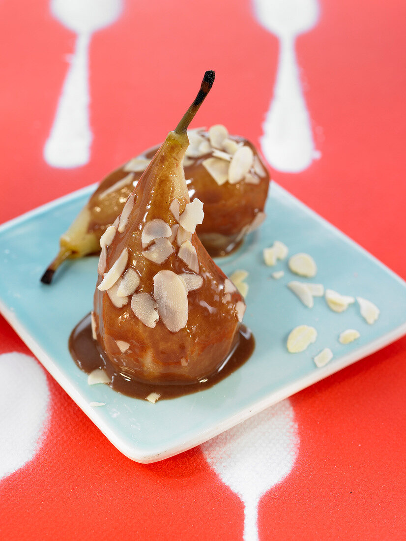 Poached pears with Carouba sauce and thinly sliced almonds