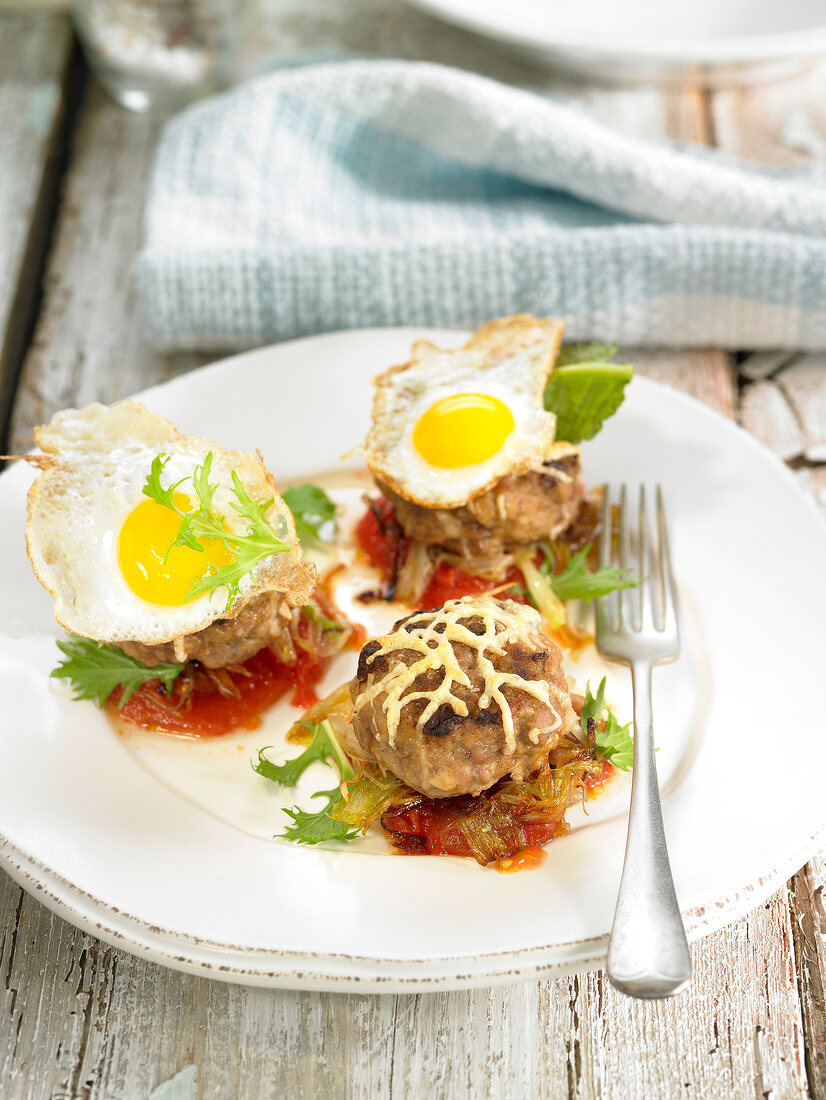 Mini horse meat burgers topped with fried quail's eggs, cheese and vegetables