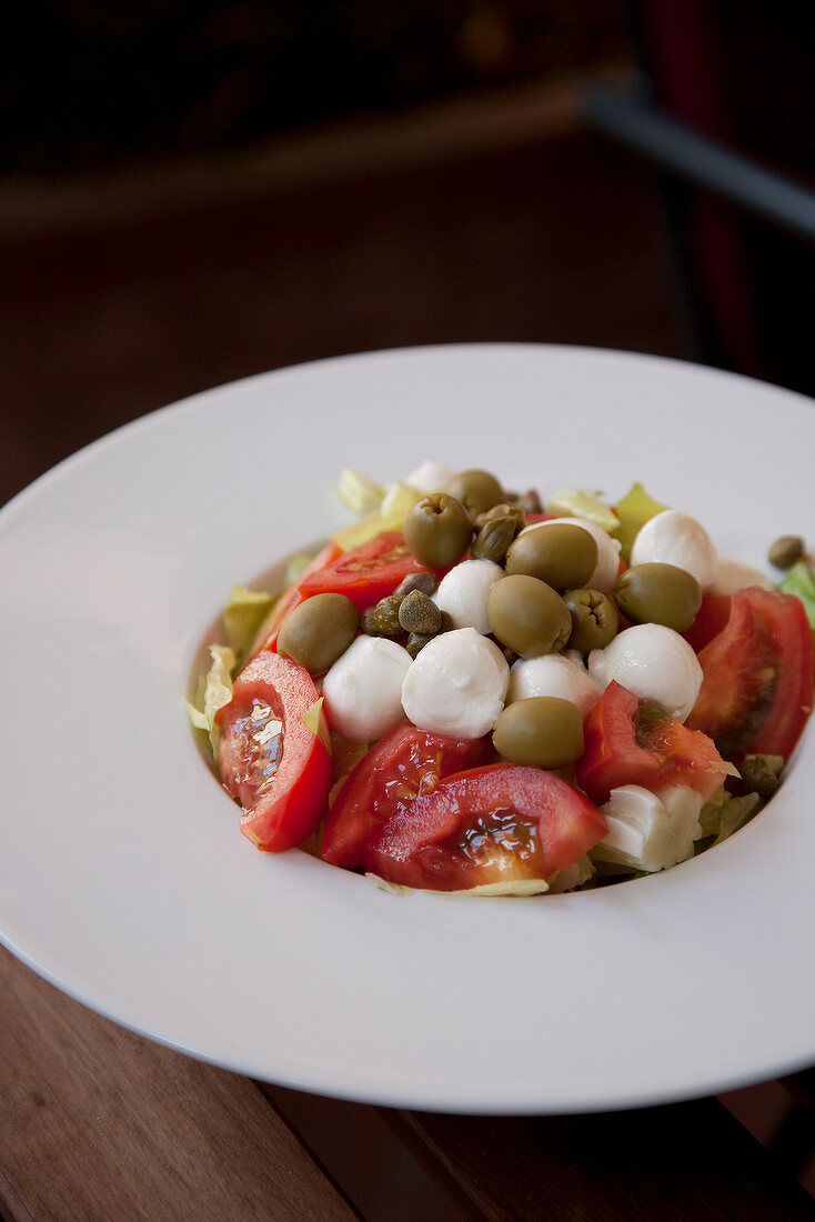 Tomato, mozzarella ball, olive and caper salad