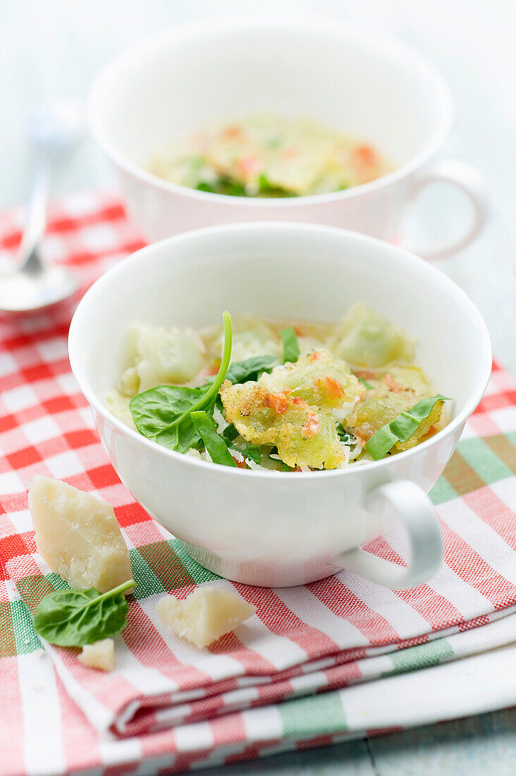 Suppe mit kleinen Spinatravioli und Parmesan