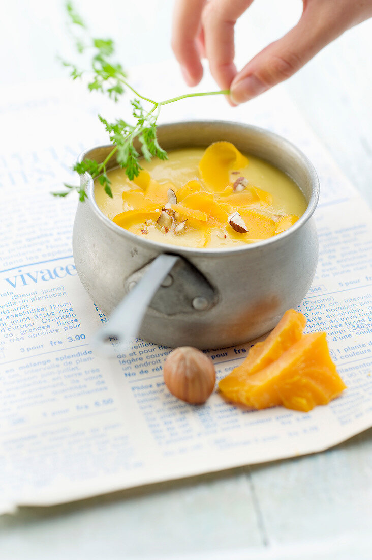 Parsnip soup with mimolette and crushed hazelnuts