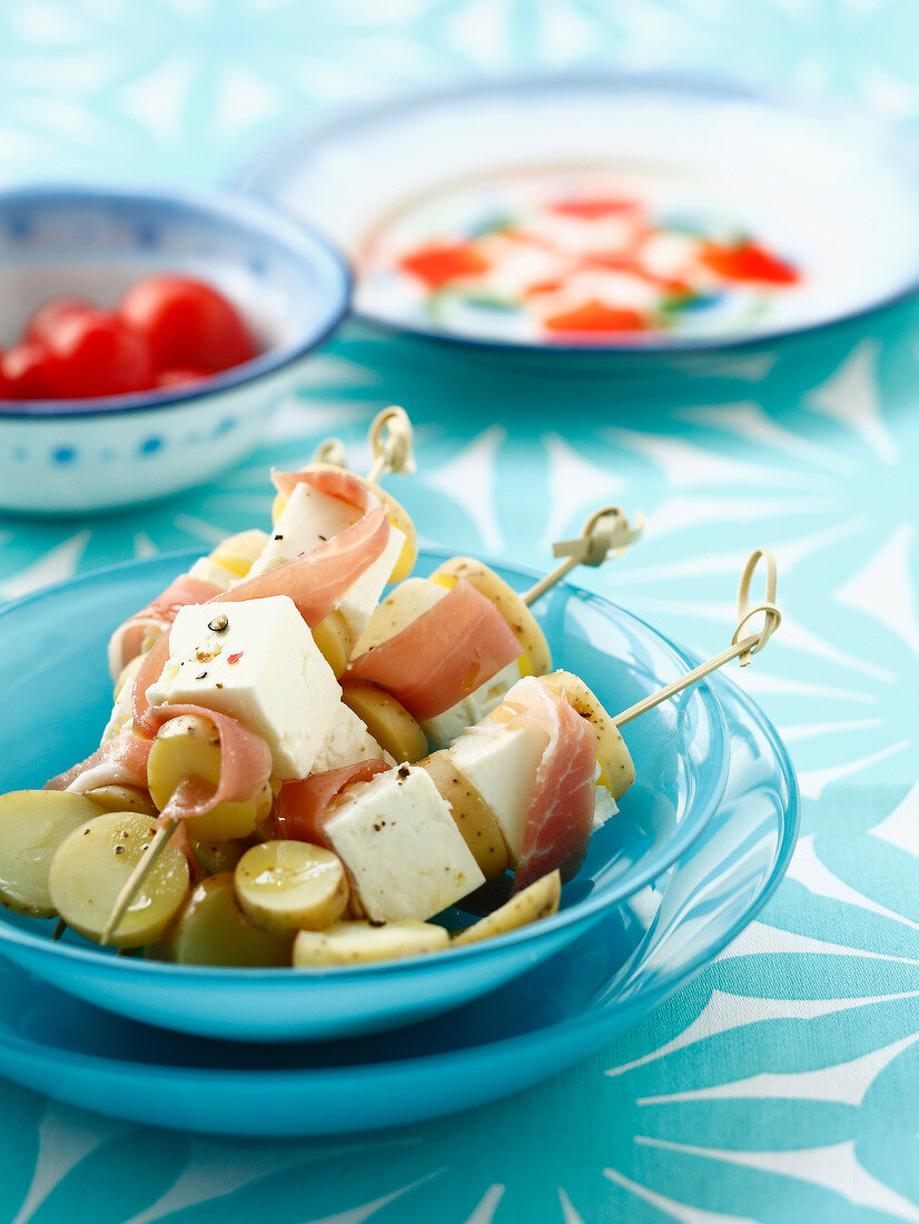 Potato, raw ham and feta brochettes