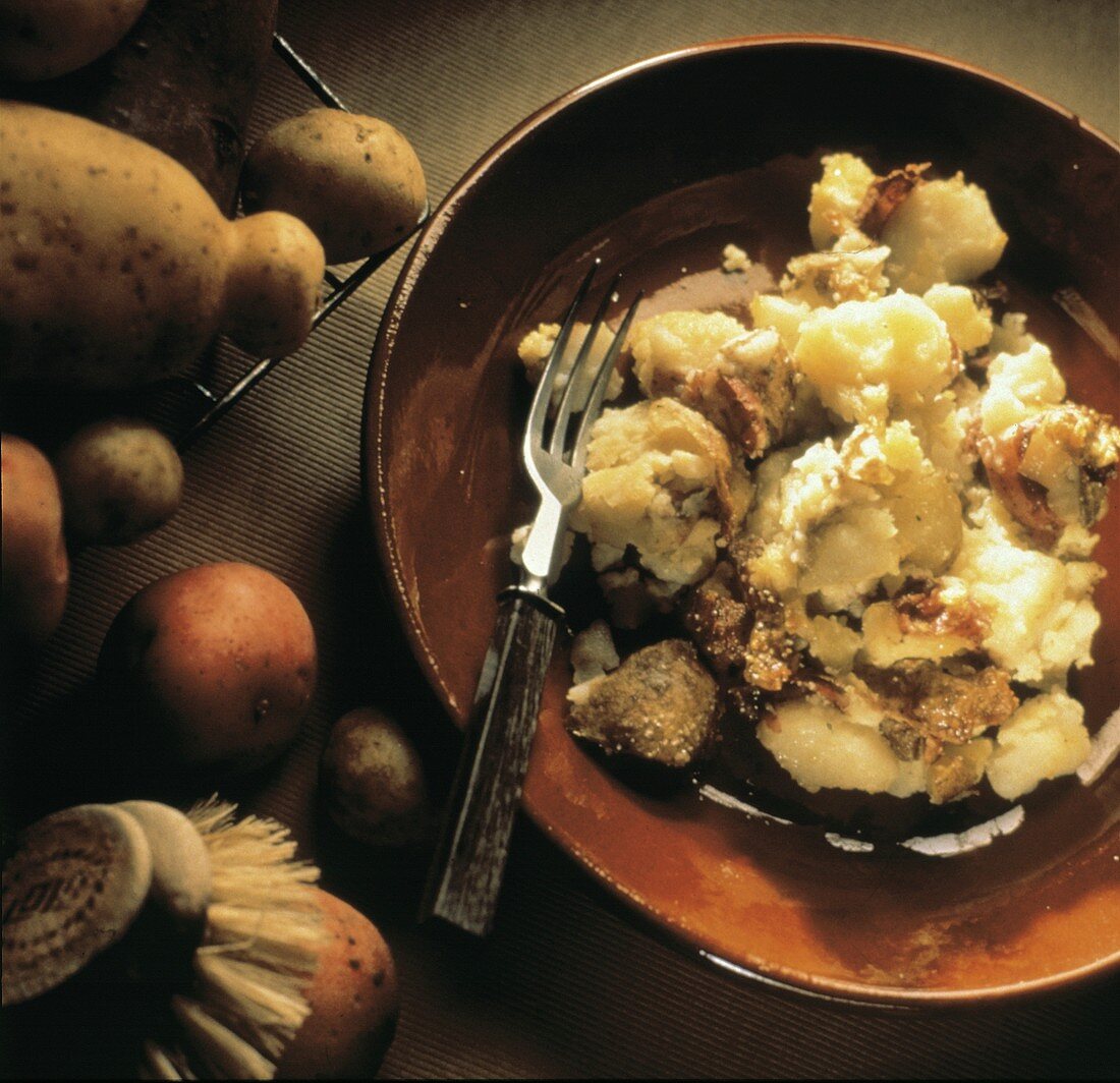Röstkartoffeln mit Schalen, von Gabel zerdrückt, auf Teller