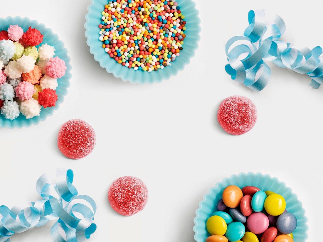 Blue paper cups full of sugar balls for decorating cakes