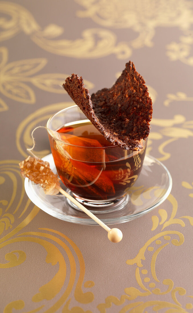 Tasse Tee serviert mit Schokoladen-Tuile