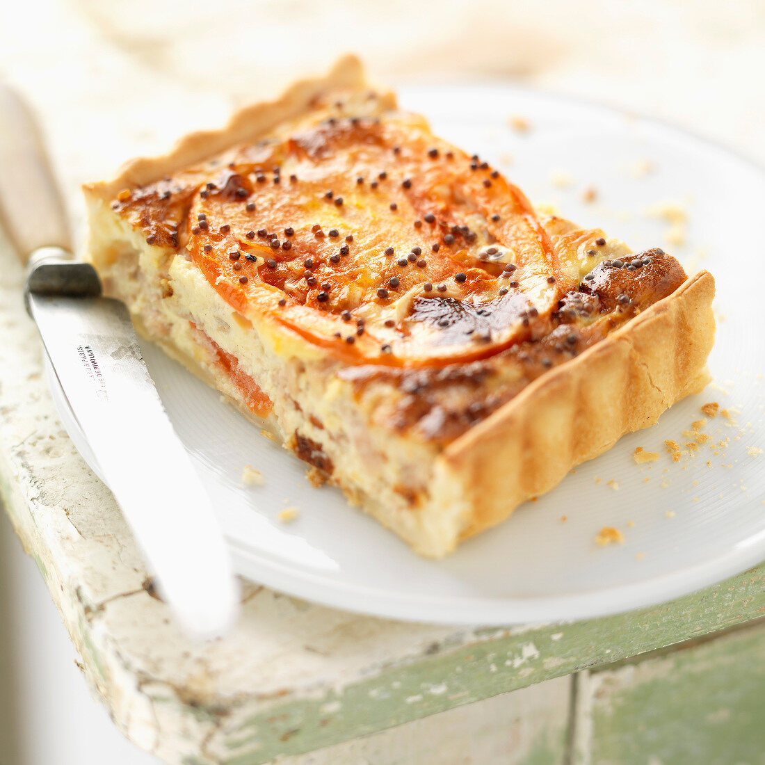 Ein Stück Thunfisch-Tarte mit Tomaten und Senf