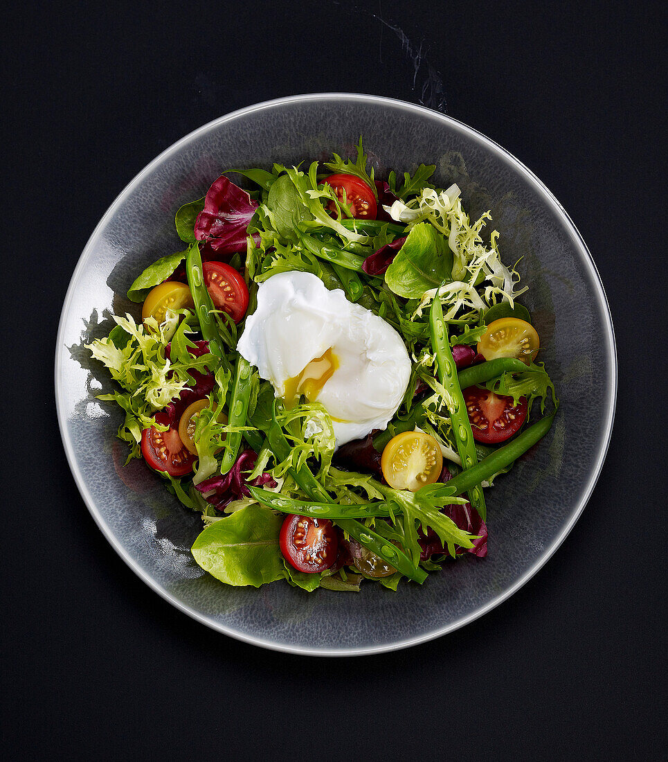 Green bean and yellow and red tomato salad with a soft-boiled egg