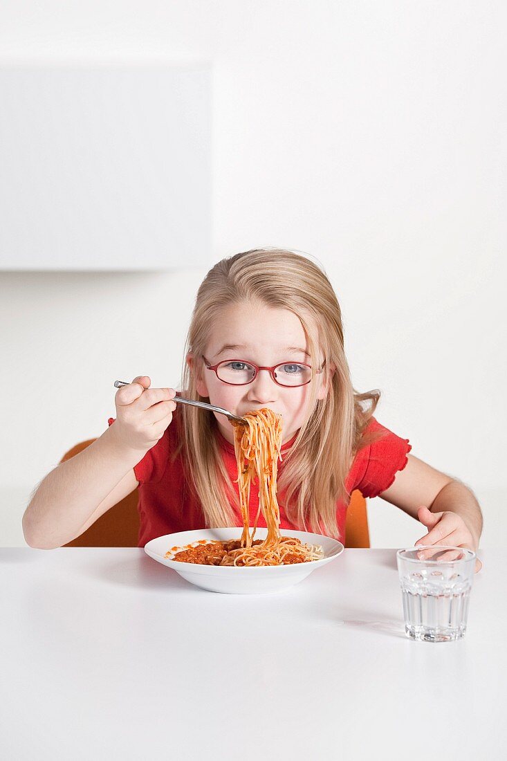 Kleines Mädchen isst Spaghetti alla Bolognese
