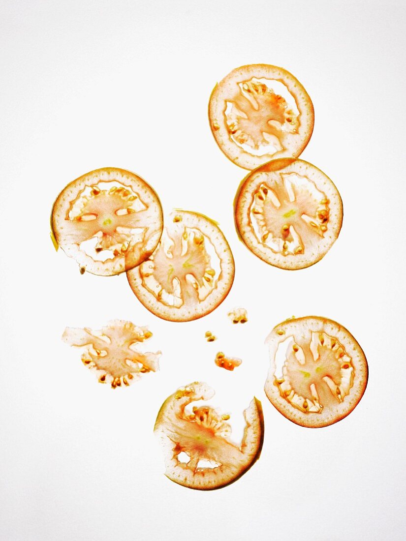 Thinly sliced tomatoes on a white background