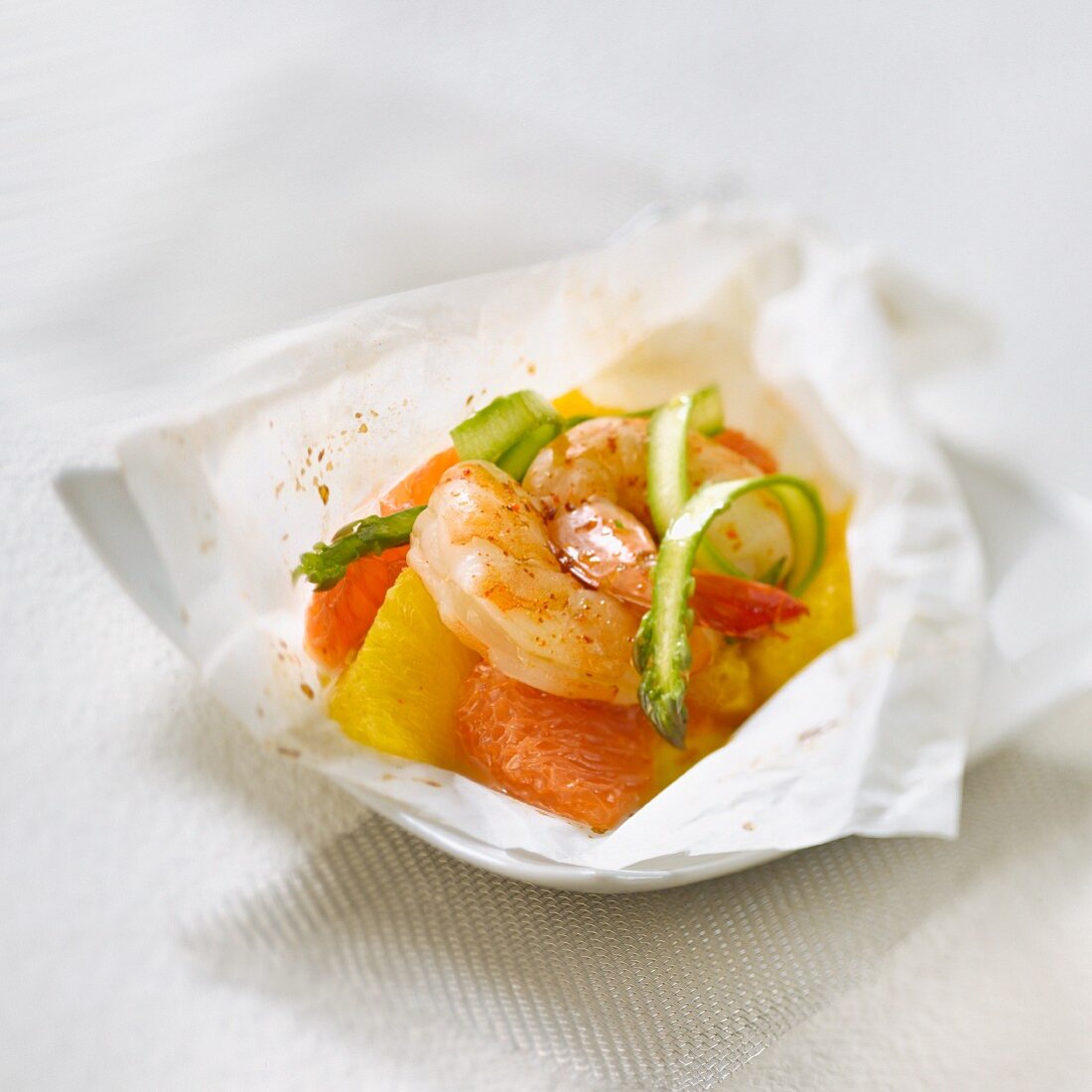 Gambas, citrus fruit, asparagus and Espelette pepper cooked in wax paper