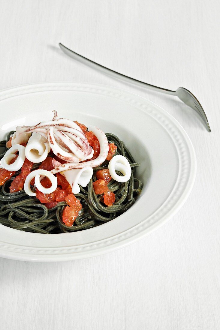 Squid ink pasta with squid and tomatoes