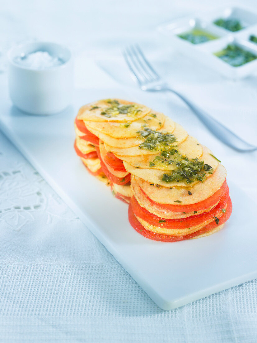 Sliced apple and tomato mille-feuille with parsley