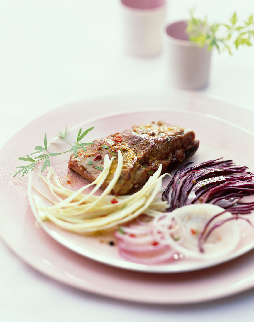 Spare ribs coated in strong mustard, thinly sliced red and white cabbage