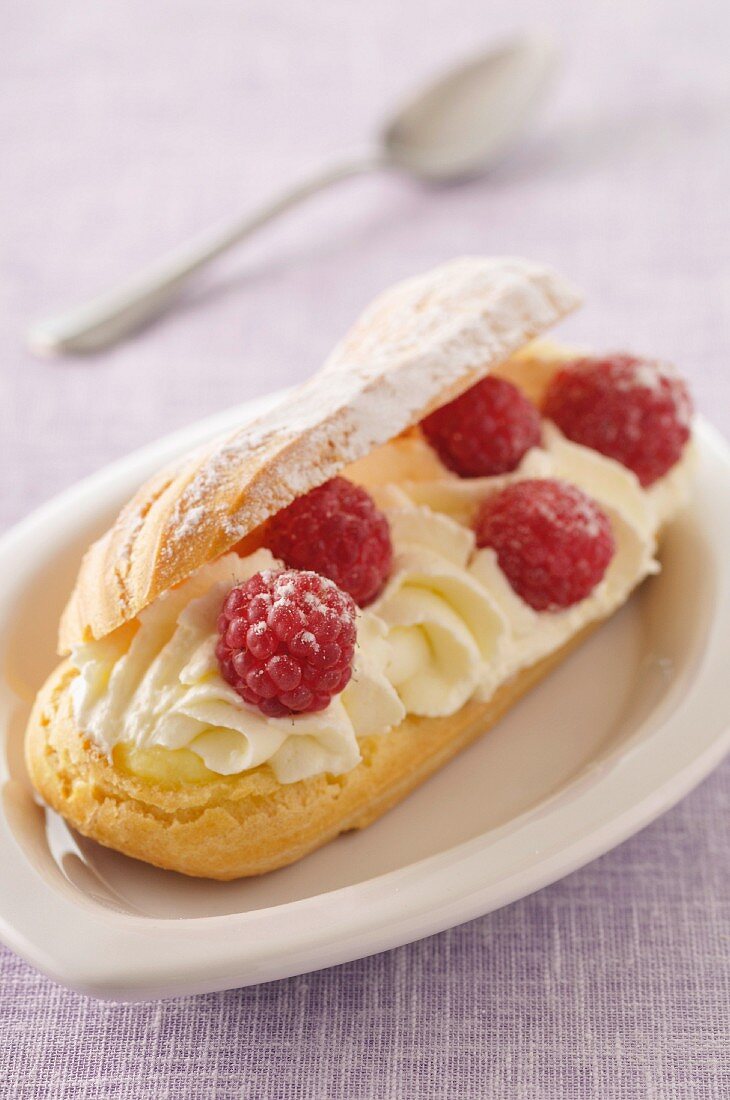 Choux bun flled with whipped cream and raspberries
