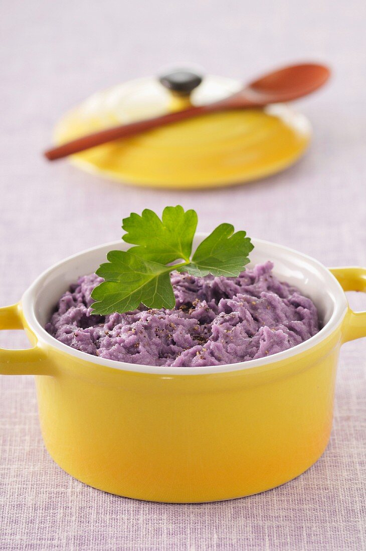 Mashed purple potatoes in a small casserole dish