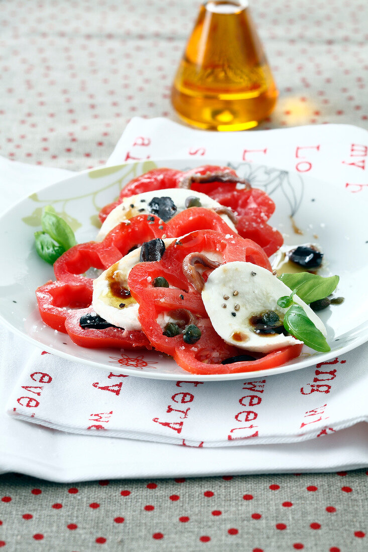 Tomaten-Mozzarella-Salat mit Kapern, Oliven, Sardellen und Basilikum