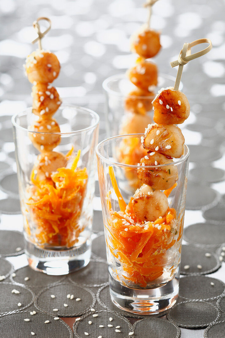 Scallop brochettes with grated carrots and sesame seeds