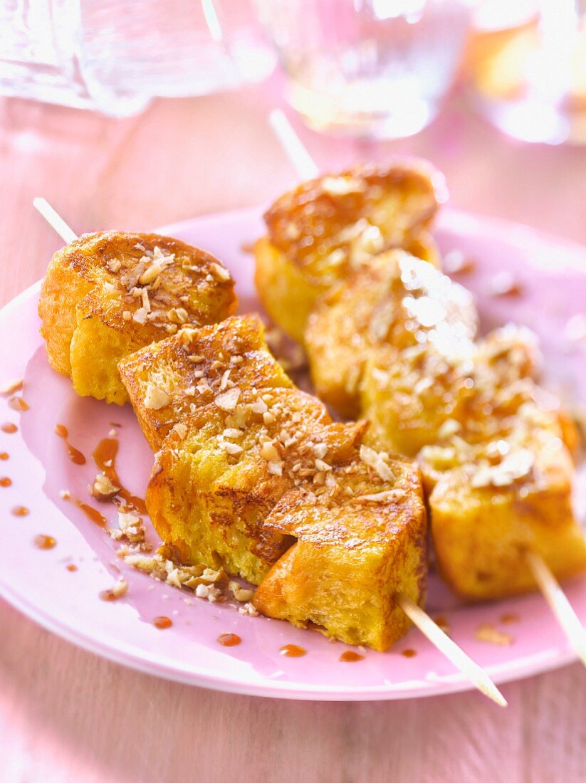 Brioche French toast brochettes with maple syrup and crushed pecans