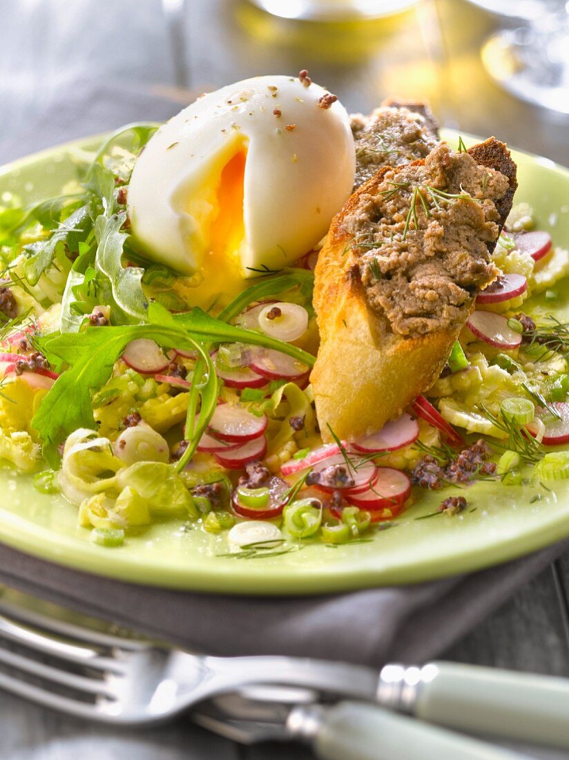 Crisp vegetable salad with a soft-boiled egg,toast with anchoyade