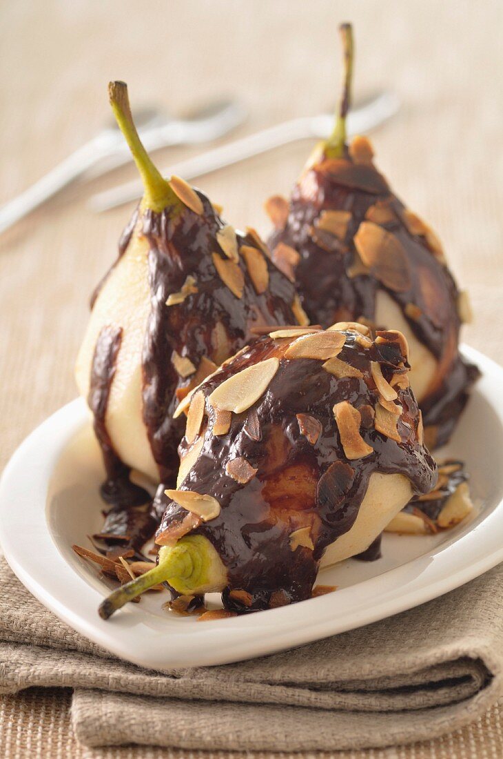 Stewed pears with chocolate sauce and thinly sliced almonds