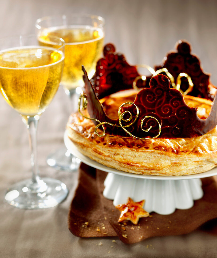 Galette des rois with a chocolate crown, glasses of cider