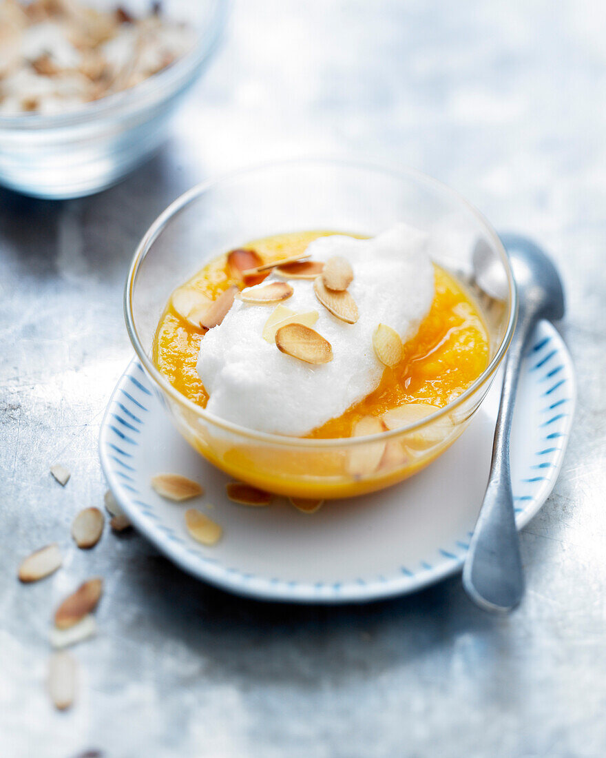 Stewed peaches with beaten egg whites and thinly sliced almonds
