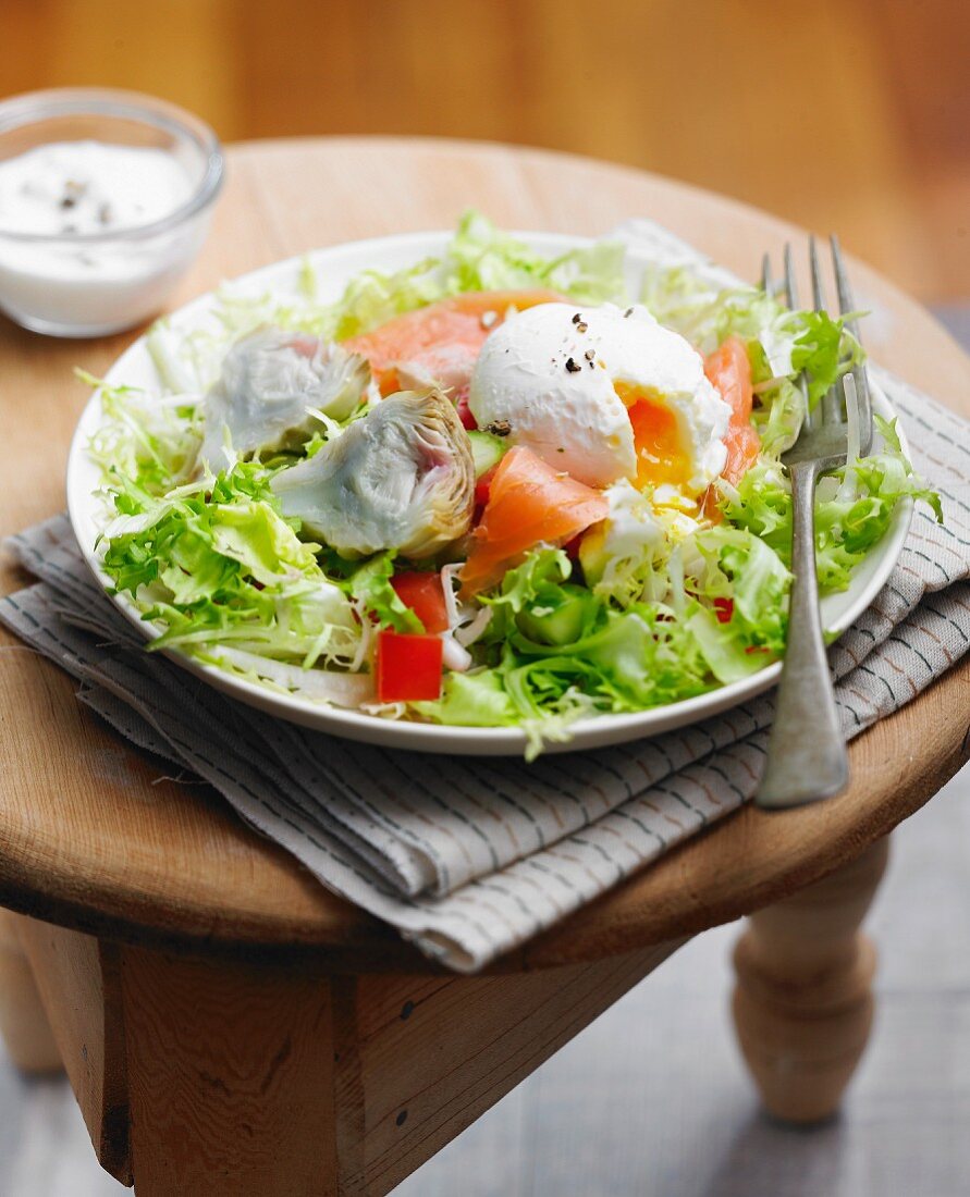 Salmon and artichoke mixed salad with a poached egg