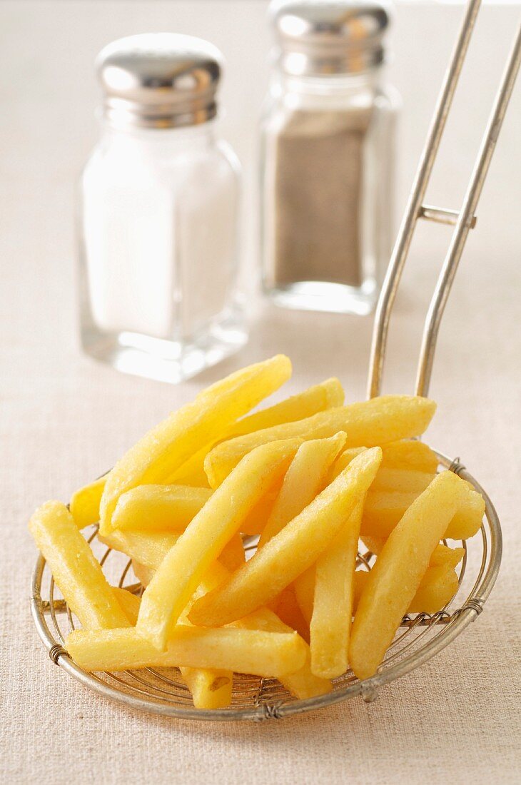 Pommes frites auf einer Schaumkelle