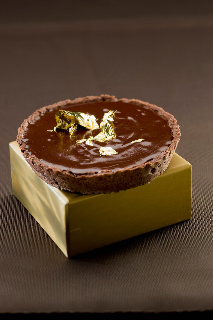 All chocolate tartlet with golden flakes