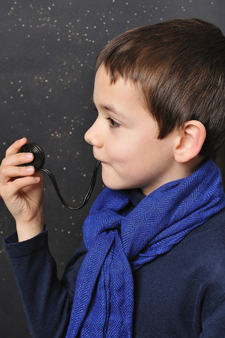 Young boy eating a licorice roll