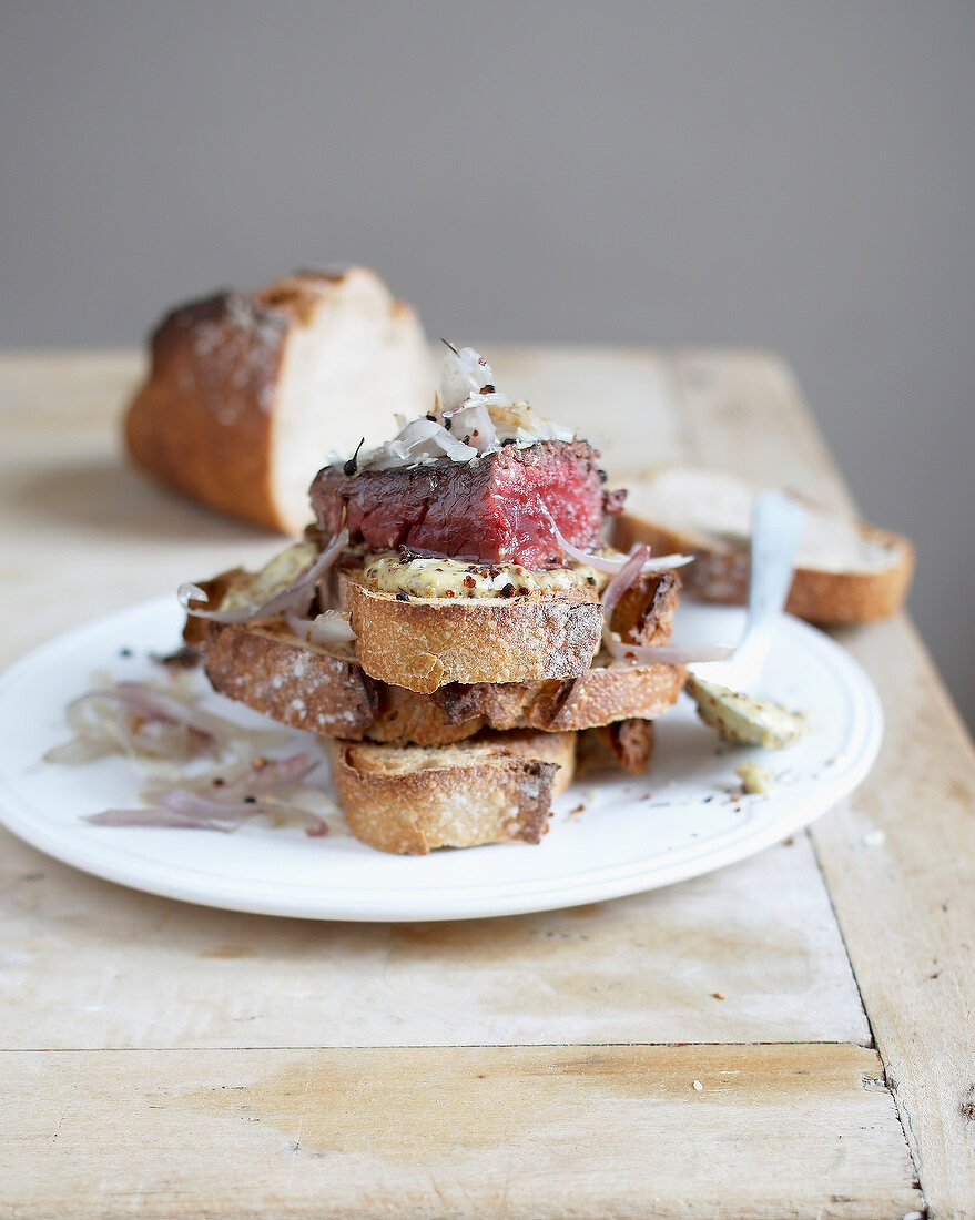 Rump steak with shallots on sliced bread