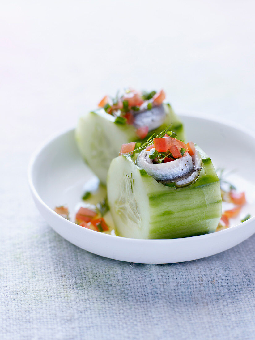 Gurkenstücke mit Anchovis und Tomatenwürfeln