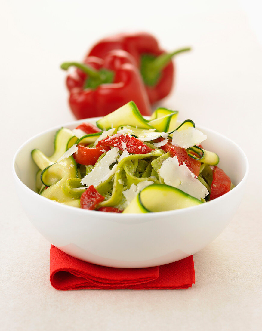 Thin strips of zucchini with red peppers and parmesan