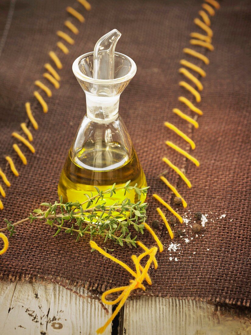 Fläschchen Olivenöl und Zweig Thymian