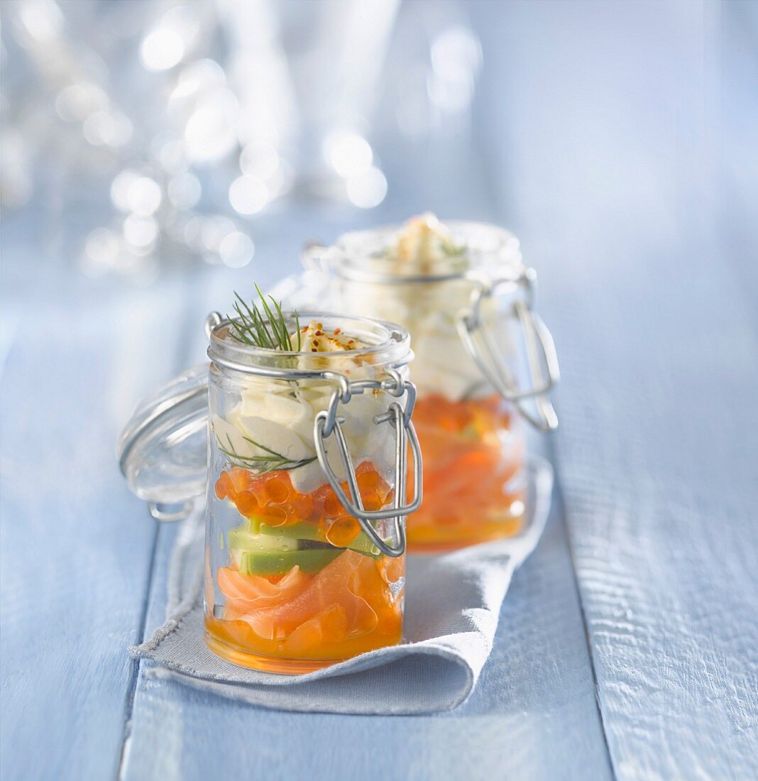 Frischer und geräucherter Lachs mit Avocado und Schlagsahne, in Gläsern serviert