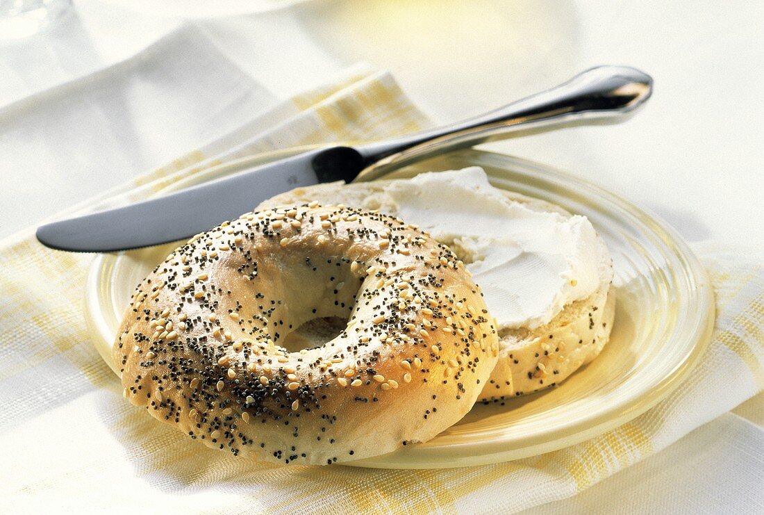 Sliced Multi-seed Bagel on Plate with Cream Cheese