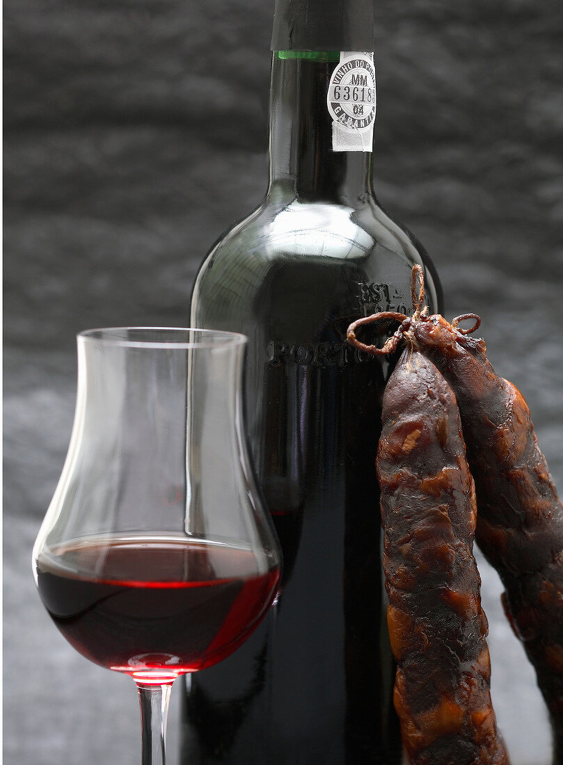 Portwein in einer Flasche und einem Glas mit Chorizo