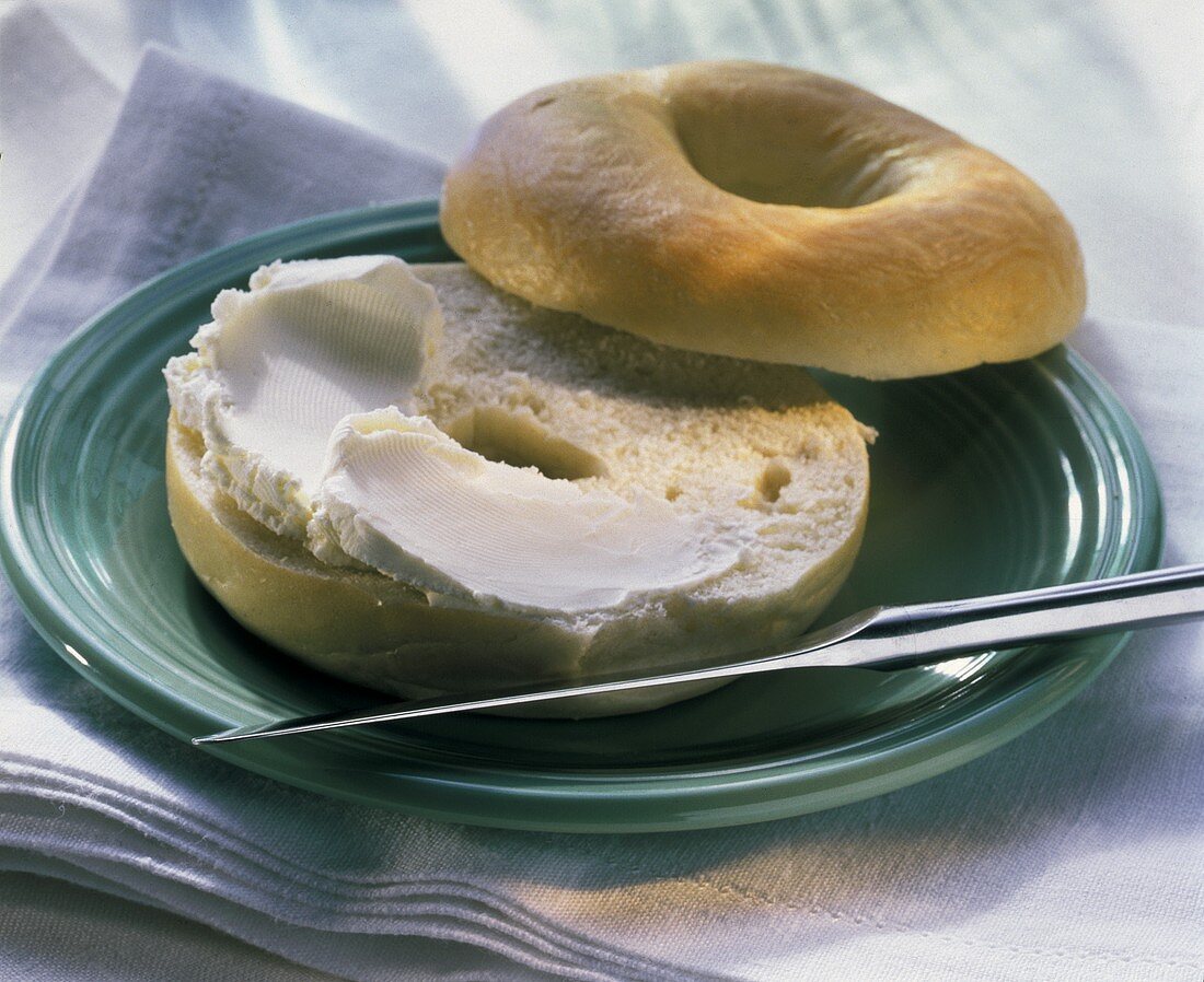 Sliced Plain Bagel with Cream Cheese on Plate