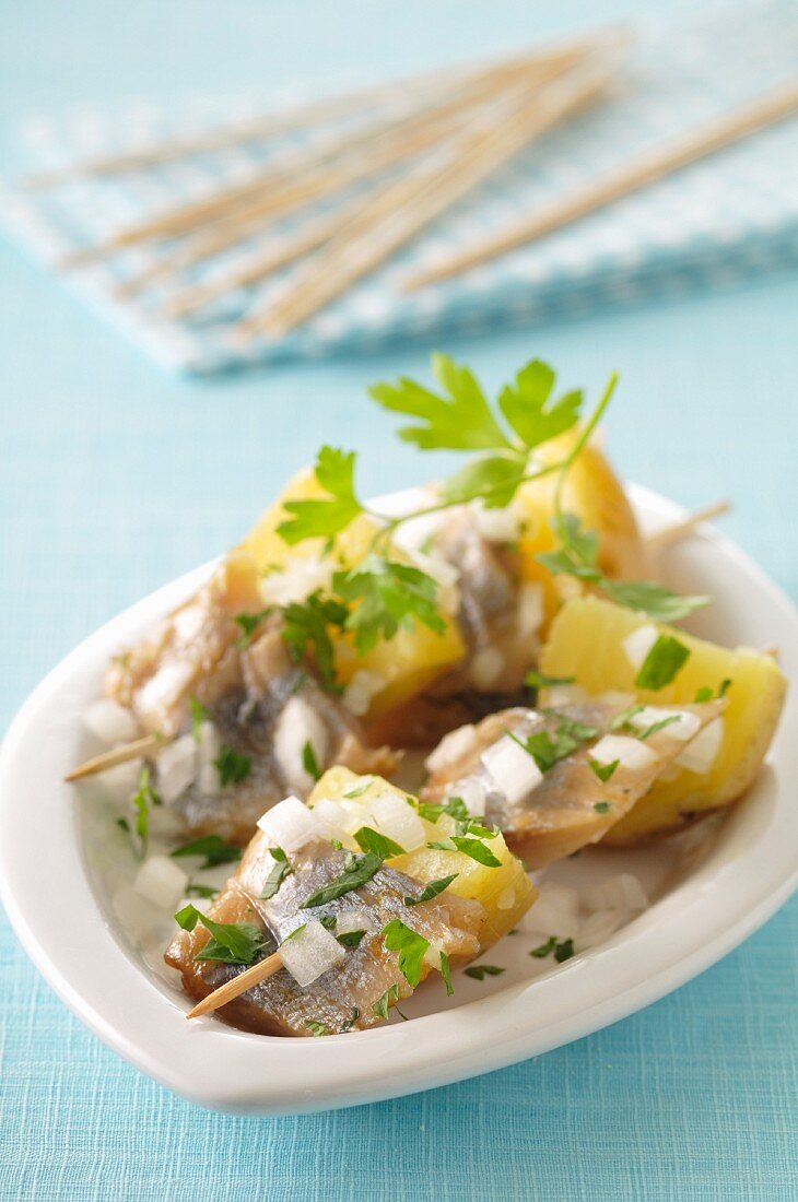 Potatoes marinated in oil and herring brochettes