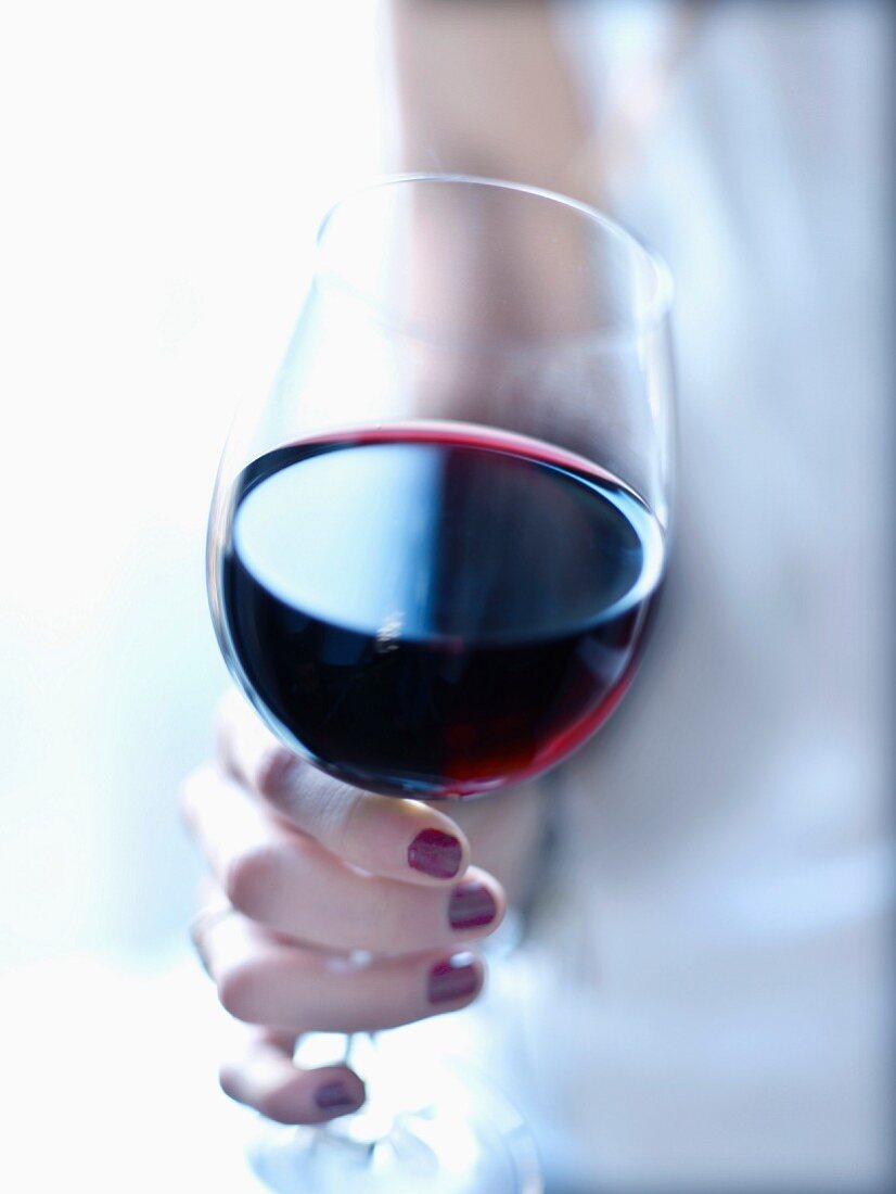 Frau hält ein Glas Rotwein