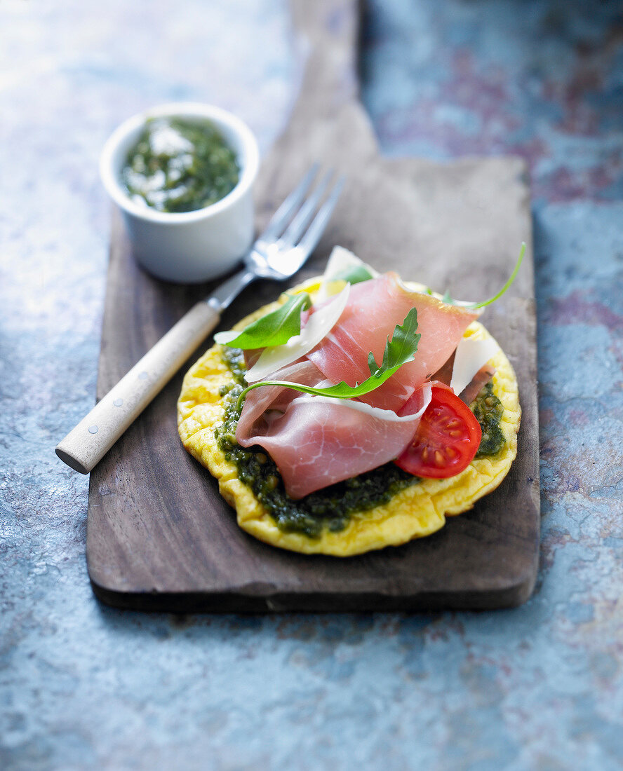 Pizza-style omelette with raw ham and pesto