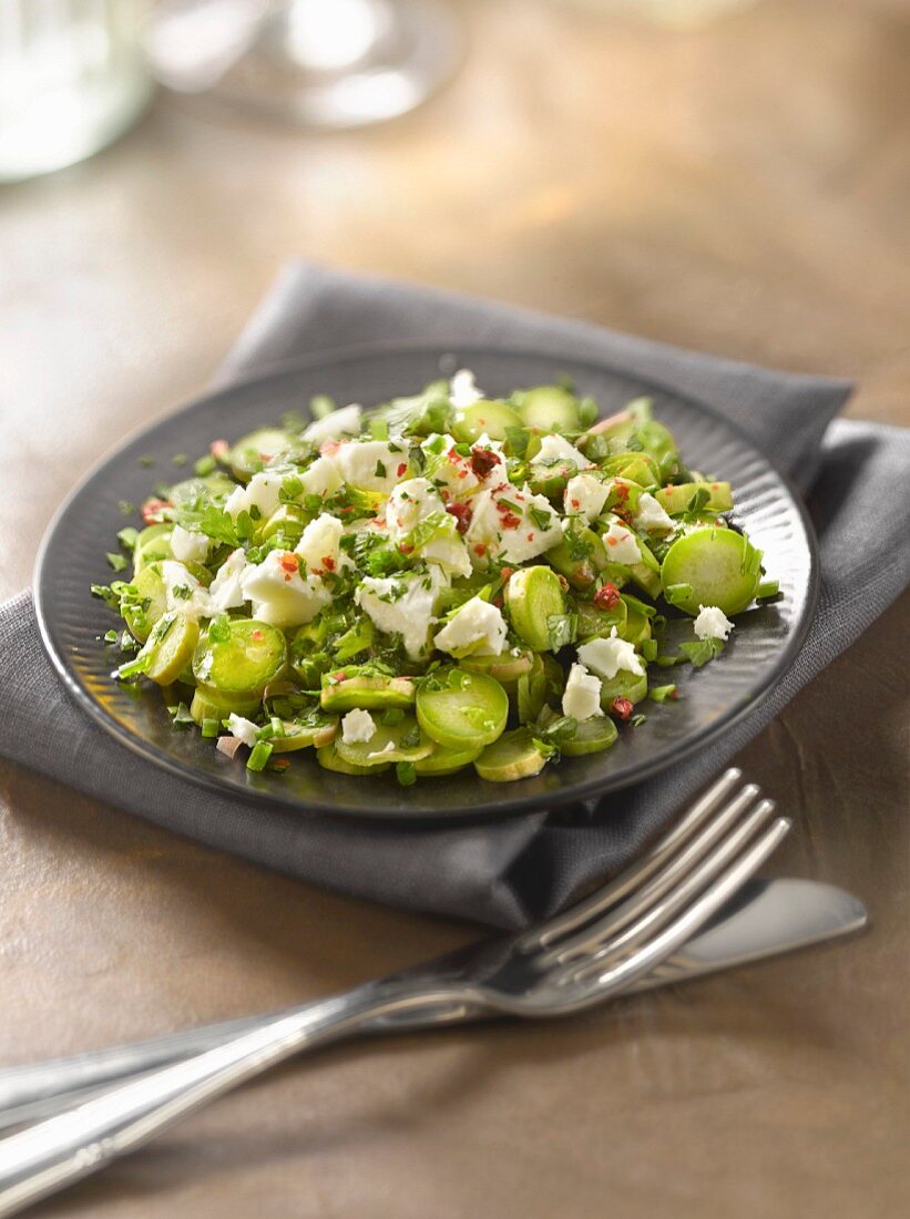 Thinly sliced raw asparagus and feta salad with herb pesto