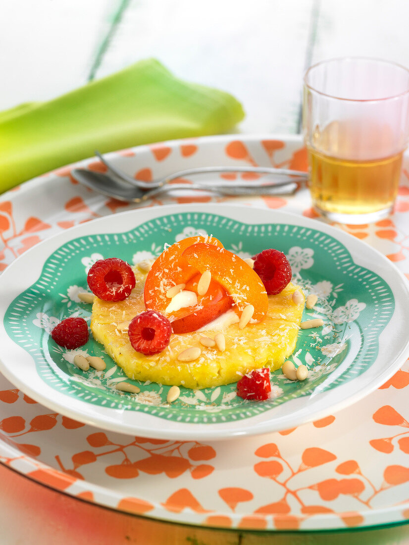 Pineapple ring with apricots, raspberries, pine nuts and coconuts