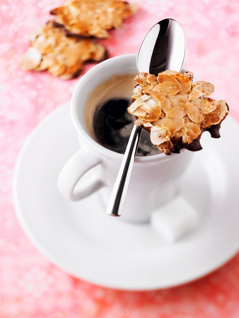 Chocolate and thinly sliced almond cookies and a cup of coffee